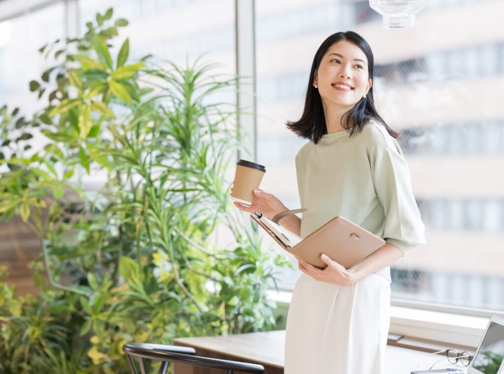 リモートオフィスを活用し、会議室の大型モニターを通じて遠隔地のメンバーとWeb会議を行うビジネスパーソンの様子